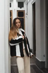 Campera con capucha, de tela tipo peluche a rayas verticales color marrón y blanco, con ribete color beige.