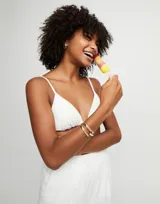 Pulsera rígida de aleación de metales bañada en oro de 18k, con diseño abierto de doble vuelta y logo de la marca grabado en uno de los extremos.