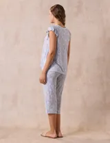 Conjunto de pijama marca René Rofé, compuesto por una remera de escote en V con botones y un pantalón capri con cintura elastizada, ambos en tejido soft estampado con motivos florales en tonos celeste y blanco.