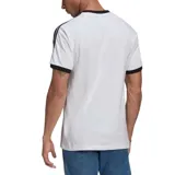 Remera blanca de algodón con cuello redondo y mangas cortas con ribete negro. Presenta las tres tiras características de Adidas en negro a lo largo de los hombros y el logo de Adidas bordado en el pecho.