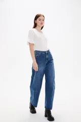 Pantalon de jean estilo barrel con tiro alto y bolsillos laterales. Presenta un corte amplio y relajado en las piernas con un lavado azul clásico.