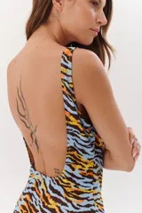 Malla enteriza negra con estampado de hojas de palmeras, flores y aves exóticas.