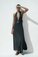 Vestido midi negro de tejido fluido, con cuello halter que se anuda en la nuca y escote pronunciado en pico.