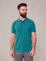 Remera polo color verde con detalles en azul marino en el cuello y puños, cierre frontal con botones y logo bordado en el pecho.