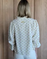 Blusa de algodón con cuello mao y volados, mangas largas con puños elásticos y corte holgado.