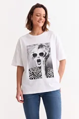 Remera blanca de algodón con estampa fotográfica en blanco y negro de una mujer con anteojos de sol y camisa con patrón geométrico.
