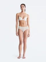 Bombacha hipster color beige de microfibra ligera con bordes cortados a láser y logo de Calvin Klein estampado en la cadera.