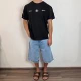 Remera negra de corte regular con estampado blanco en la espalda que incluye un diseño ovalado con espirales, la palabra "BREATHEfast" y la frase "Feel the Vcp Concept Drift".