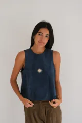 Chaleco de gamuza suave en color azul marino, sin mangas, con cuello redondo y diseño bordado de sol en el centro del pecho.