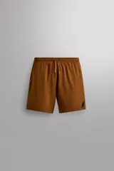 Pantalón corto deportivo color marrón, confeccionado en tejido técnico ligero y elástico, con forro interior. Presenta cintura elástica ajustable con cordón, bolsillos frontales, bolsillo de seguridad trasero con cierre y aberturas laterales en el bajo.
