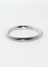 Pulsera rígida elastizada de acero quirúrgico hipoalergénico color plateado.