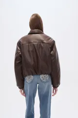 Campera estilo bomber de eco-cuero negra, con cuello camisero, cierre frontal y puños y cintura ajustados con elástico.
