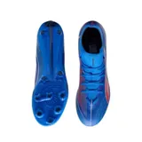 Championes de fútbol Puma Ultra 6 Match+ con diseño de corte medio, color azul con detalles en naranja y blanco. Presentan una estructura ligera con cordones y suela con tapones para superficies firmes y artificiales.