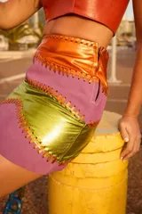 Minifalda con piezas de cuero cosidas a mano, con cierre metálico.