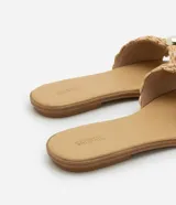 Sandalia plana de color beige con tira ancha confeccionada en rafia trenzada con diseño de nudo. Presenta un detalle decorativo de esfera perlada en el centro, punta redondeada y suela fina de 1 cm.