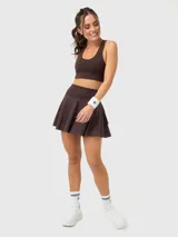 Top deportivo de color marrón chocolate, con escote redondo, espalda con tirante central grueso y sujetador integrado. Presenta un diseño minimalista con logo sutil en el pecho.