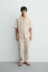 Pantalón relaxed fit de lino color negro, con cintura elástica ajustable con cordón y bolsillos frontales.