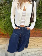 Jean ancho azul de corte wide leg, con diseño de costuras curvas decorativas en la parte delantera y tiro bajo.