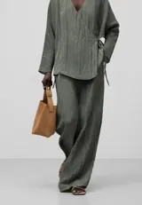 Pantalón de poliéster reciclado color verde oliva, con cintura elástica, pinzas delanteras, bolsillos laterales y pierna recta.