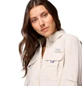 Camisa de manga larga color beige, diseñada para actividades al aire libre y pesca. Presenta un corte relajado, múltiples bolsillos frontales con solapa, ventilación en la espalda, presillas utilitarias y mangas enrollables con ajuste de botón.