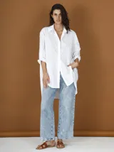 Camisa blanca de poplin con strass aplicados, corte clásico, cuello camisero y mangas largas con puños abotonados.