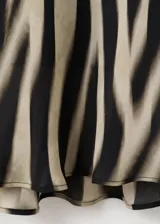 Vestido midi de poliéster con estampado animal print tipo cebra en tonos marrón y negro, escote redondo y manga larga.