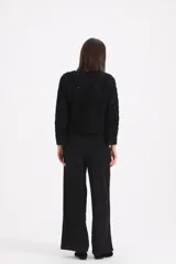 Pantalon de vestir negro de corte recto y tiro alto, con cintura ancha y cinto de lazo integrado en la misma tela.