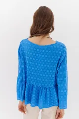 Camisa color crema con bordados florales, escote en V, mangas largas y cierre frontal con botones.