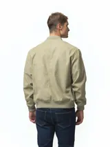 Campera tipo bomber color gris, con cierre frontal completo, bolsillos laterales con cierre y puños y ruedo acanalados.