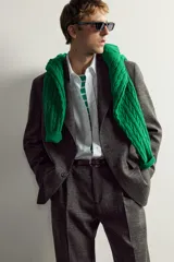 Blazer regular fit de Zara, confeccionada en tejido con mezcla de lana y lino en color gris oscuro con efecto jaspeado. Presenta cuello con solapas de muesca, manga larga con botones en los puños y un cierre frontal de un botón. Incluye bolsillos con solapa en la cadera, un bolsillo de vivo en el pecho y aberturas en la parte trasera.