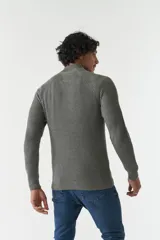 Sweater gris de punto con cuello alto y medio cierre con cremallera.