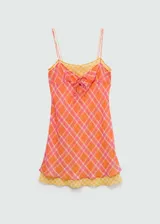 Vestido corto de tirantes finos dobles, con diseño recto y escote de pico. Presenta un estampado de cuadros en tonos naranja y rosado, con un lazo decorativo en el centro del pecho.