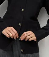 Cardigan de punto color negro con escote en V, cierre frontal con botones, mangas largas con puños acanalados y bolsillos frontales funcionales.