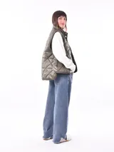 Chaleco verde militar con diseño acolchado de rombos, cuello alto y cierre frontal con botones a presión.