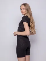 Calza ciclista negra de tela brillante con textura acanalada y elástico en la cintura.