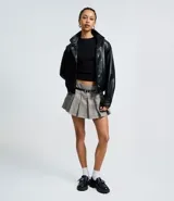 Short pollera de estilo sastre con estampado de cuadros, diseño plisado y cintura con trabillas. Incluye un cinturón ajustable con hebilla metálica.