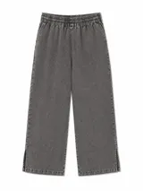 Pantalón de jean azul oscuro, de corte ancho y relajado, con cintura elástica fruncida y cordón ajustable.