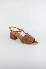 Sandalias de cuero rojo con diseño de tiras horizontales abullonadas en la parte delantera, punta fina, tira vertical central en forma de T y tira ajustable al tobillo. Poseen tacón cuadrado de madera de 6 cm.