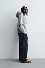 Sudadera tipo hoodie de corte relajado, confeccionada en tejido de algodón con interior cepillado. Presenta capucha con cordones ajustables, bolsillo frontal tipo canguro y terminaciones en rib en puños y ruedo.