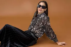 Camisa de manga larga con estampado animal print abstracto en tonos negros, marrones y beige. Presenta cuello alto, cierre frontal abotonado y mangas con volumen.