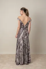 Vestido largo de satén de seda estampado en tonos chocolate y natural, con escote off-shoulder y falda con movimiento. Incluye lazo para ajustar la cintura y tul transparente en el escote.