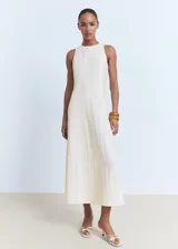 Vestido midi de corte evasé, sin mangas, con cuello caja y cierre posterior de cremallera y botón.