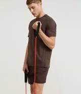 Bermuda deportiva de hombre color marrón, con cintura elástica ajustable mediante lazo y estampa heat print. Confeccionada en tejido de poliéster de secado rápido, diseñada para brindar comodidad y libertad de movimiento durante la actividad física.