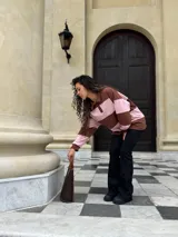 Buzo deportivo de corte holgado con diseño de rayas horizontales anchas en color marrón y rosado. Presenta cuello tipo polo con cierre frontal de botones y mangas largas con puños ajustados.