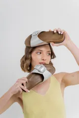 Sandalias plateadas con hebilla metálica, plantilla anatómica y base marrón.