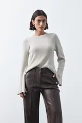 Pantalón de corte recto y pierna amplia confeccionado en símil cuero color marrón oscuro. Presenta una silueta estructurada con costuras verticales frontales que definen su diseño.