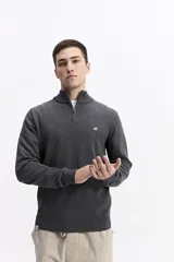 Buzo de punto con medio cierre frontal, cuello elevado y puños acanalados. Presenta un pequeño logo bordado en el pecho.