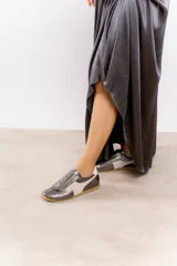 Zapatillas plateadas con detalles en cuero y gamuza color beige. Diseño con puntera perforada, cierre con velcro y suela de goma color caramelo.