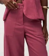 Pantalón de mujer estilo pantacourt (largo a media pierna) color fucsia/rosado, confeccionado en viscolino (mezcla de viscosa y lino). Presenta cierre tradicional y bolsillos.