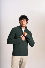 Sweater de punto acanalado en color verde oscuro, con cuello alto y cierre frontal parcial de un cuarto. Presenta puños y ruedo elásticos, con el logo de la marca bordado en el pecho.